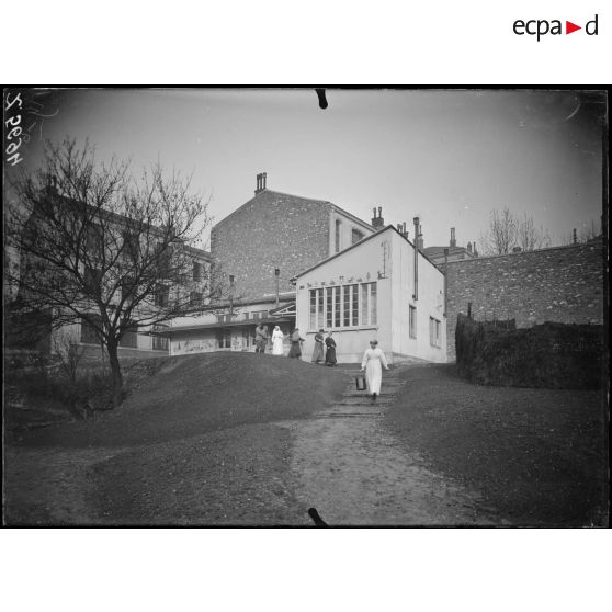 Paris. Pouponnière du camouflage (passage de l'Atlas). Vue générale de la pouponnière, femmes venant d'allaiter leur enfant. [légende d'origine]