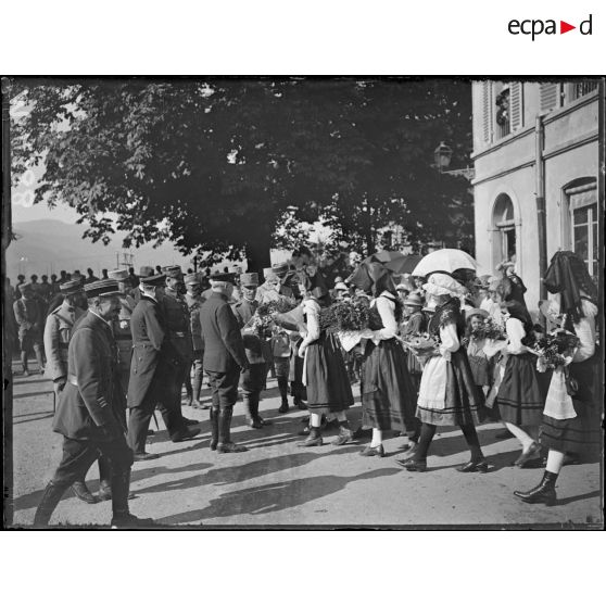 Masevaux, sur la place, les jeunes alsaciennes remettant des fleurs au roi. [légende d'origine]