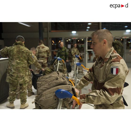 Un instructeur français attend d'enregistrer ses bagages au guichet d'embarquement à l'aéroport de Roissy-Charles-de-Gaulle.