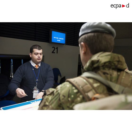 Un instructeur britannique enregistre ses bagages au guichet d'embarquement à l'aéroport de Roissy-Charles-de-Gaulle.
