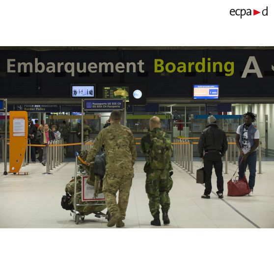 Des instructeurs européens se dirigent vers la zone d'embarquement à l'aéroport de Roissy-Charles-de-Gaulle.