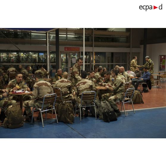 Des instructeurs français au petit-déjeuner dans une cafétéria de l'aéroport de Roissy-Charles-de-Gaulle.