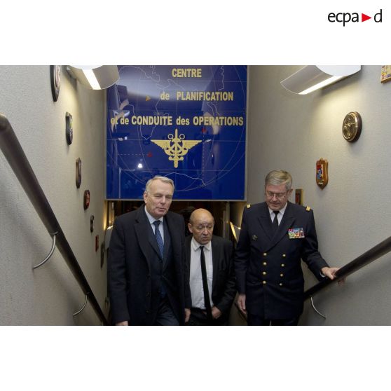 Le Premier ministre Jean-Marc Ayrault discute avec le ministre de la Défense Jean-Yves Le Drian et l'amiral Edouard Guillaud, chef d'état major des armées (CEMA), au terme d'une réunion au centre de planification et de conduite des opérations (CPCO).