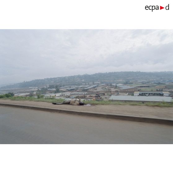 Convoi dans les rues de Kigali. Un cadavre gît sur le bord la route.