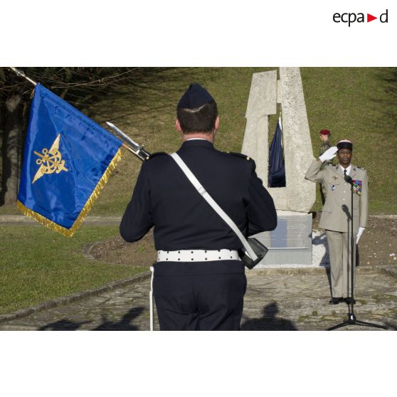 Le commissaire en chef de première classe Lucien Oulac salue le fanion de l'ECPAD lors d'une cérémonie au fort d'Ivry.