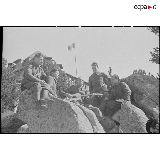 Moment de détente pour des permissionnaires entourant un guitariste.