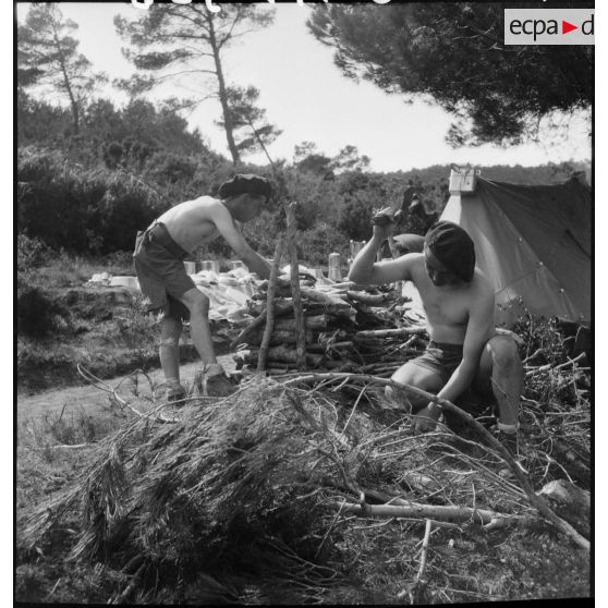 Des fantassins coupent du bois sur le campement du 43e RIA.