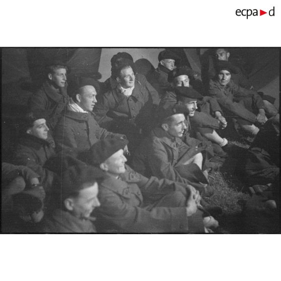 Des fantassins du 43e RIA assistent au spectacle de nuit sur le campement de l'unité.