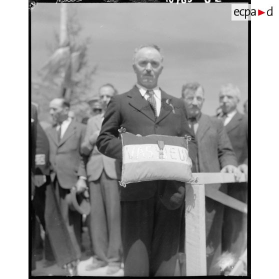 Le maire de Vassieux-en-Vercors présente la croix de la Libération que Georges Bidault, président du Conseil national de la Résistance (CNR), vient de lui remettre à l'occasion de la première commémoration des combats du Vercors.