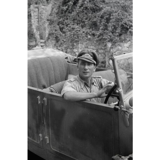 Un capitaine (Hauptmann) de la Luftwaffe aux commandes d'un véhicule (conduite à droite), il pourrait s'agir d'un véhicule de prise.