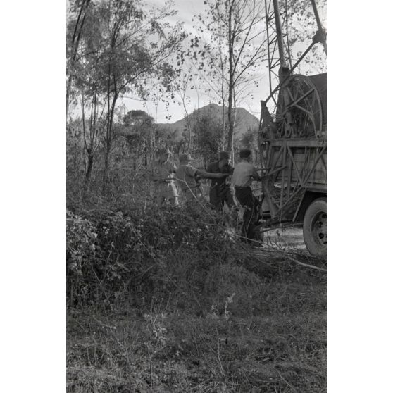 Dépannage d'une voiture par une grue Kfz-Aufsetzkran 3t installée sur un camion Opel Blitz.