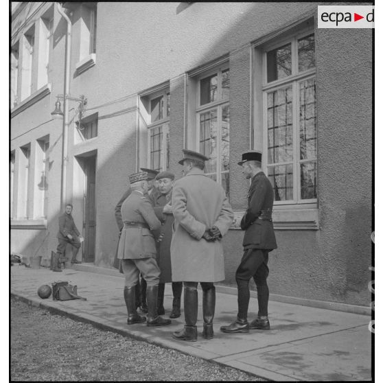 Le général d'armée Réquin discute avec deux officiers anglais et le romancier Roland Dorgelès.