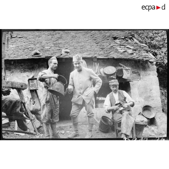 [Trois soldats devant une maison].