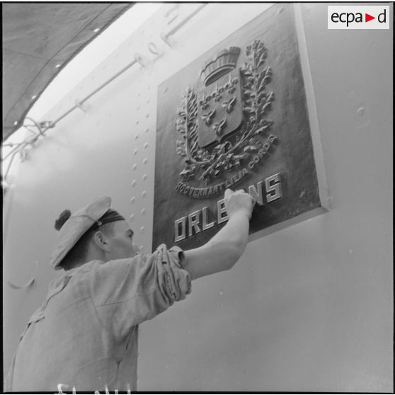 Entretien des armoiries d'Orléans à bord du croiseur la Jeanne d'Arc par un marin à Alger.