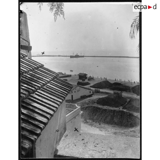 Le St-Augustin canonné le 4 août à 4h20 par le Breslau qui semblait exactement derrière la jetée dans le même sens que le Saint-Augustin. Vue prise de la montée de l'hôpital. Le Breslau était à l'endroit indiqué par une croix. L'angle de la maison en terrasse a reçu aussi un obus qui avait fait une large brèche environ à 20 centimètres de l'endroit marqué d'une croix. En s'y trouvant, on voyait la brèche où l'obus était allé éclater dans l'angle de la chambre. [légende d'origine]