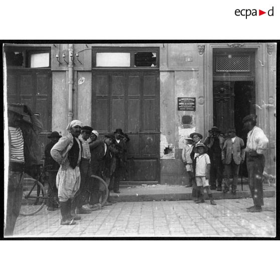 Le trou fait par un obus qui est allé éclater dans l'intérieur d'une grande salle vide inocccupée (précédemment une taverne). Cet obus n'a fait aucun mal. Derrière le trou indiqué là, il a rencontré le mur de refend dans lequel il a éclaté. Avant de toucher à cet endroit, il avait ricoché deux fois sur le pavé. [légende d'origine]
