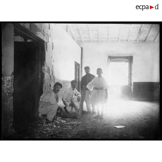 Photo prise à 8h du matin dans la manutention. Salle des farines. Un obus est entré de la fenêtre et a pénétré dans le parquet à une distance d'environ 7 ou 8 mètres de la fenêtre.  Ce qui prouve que la trajectoire en était extrémement faible et que pour venir du Breslau, l'obus a dû passer devant le 1er étage de la maison de la Place, soit en frôlant le toit de la véranda, soit même en filant dans la véranda car le bateau allemand était exactement dans la direction de la véranda. Me trouvant sur cette véranda, je voyais à droite la manutention et à gauche, exactement le Breslau. La chambre des farines en bas a été plus abîmée. [légende d'origine]