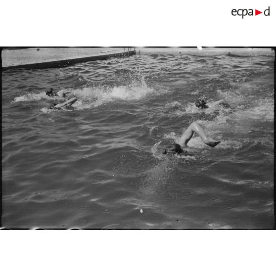 Des jeunes engagés militaires s'entraînent en natation, en plein air.