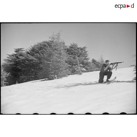 En fôret, dissimulés dans la neige, derrière les arbres, les patrouilleurs de l'école de ski de Chrea participent à un exercice de tir.