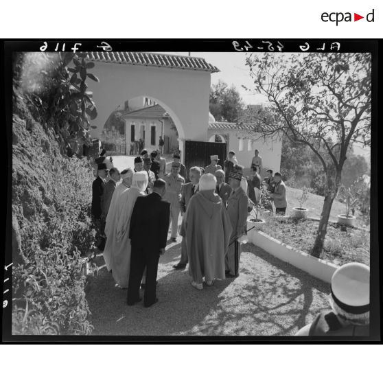 Des autorités militaires s'entretiennent avec des autorités locales à l'entrée de la maison du blessé de guerre musulman.