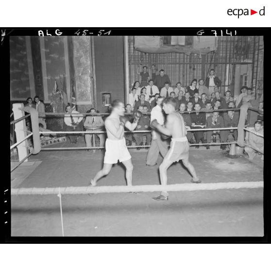 Combat de boxe auquel assistent des autorités militaires.