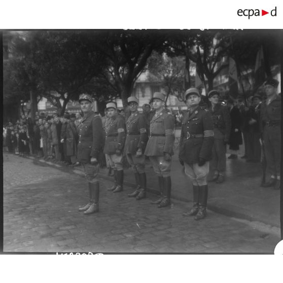 Le général de division Jean Breuillac, assisté d'autorités militaires, passe en revue des troupes, à Alger.