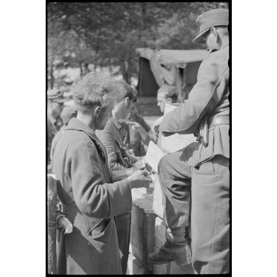 Après avoir défendu la ville de Vilnius, des fantassins allemands se ravitaillent.