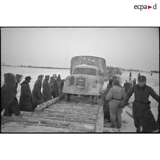 Un camion semi-chenillé Opel Maultier WH-1559 662 traverse un pont de fortune.