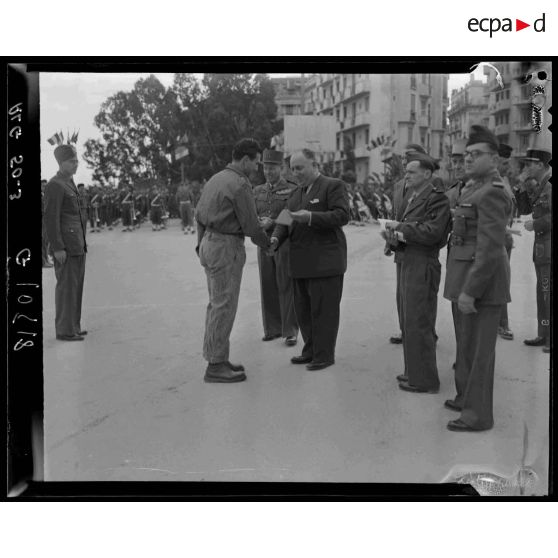 Remise de brevet à la préparation militaire à un jeune diplômé par une autorité civile au stade Leclerc d'Alger.
