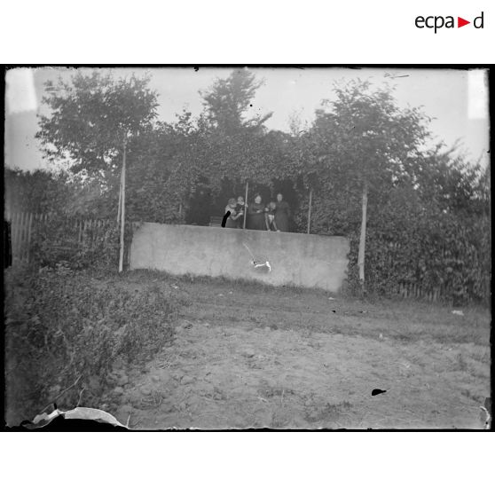 [Famille dans un jardin avec un chien].<br>