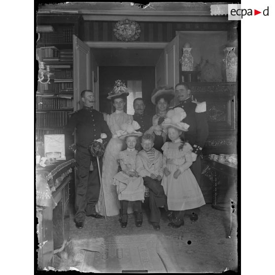 [Portrait de groupe de famille dans un intérieur bourgeois avec deux militaires en uniforme].<br>