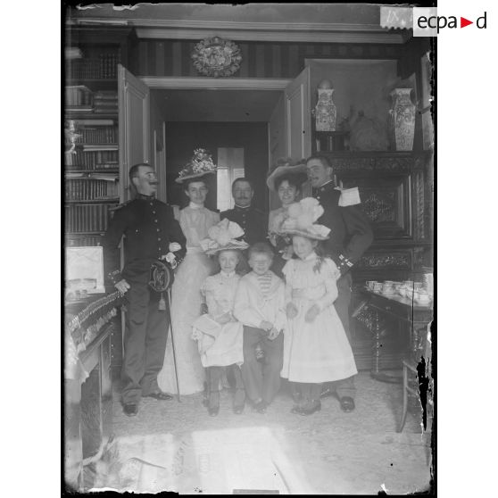 [Portrait de groupe de famille dans un intérieur bourgeois avec deux militaires en uniforme].<br>