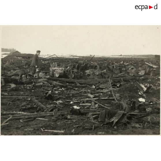 [Un soldat constate les dégâts causés par un bombardement, au centre un side-car].