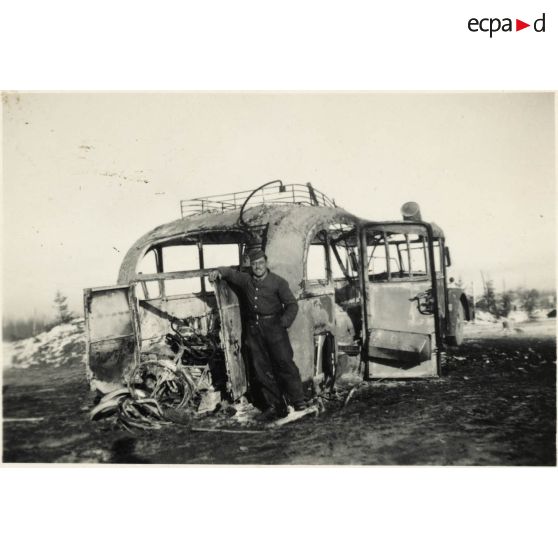 [Un soldat de l'armée de Terre allemande pose devant un autocar Henschel].