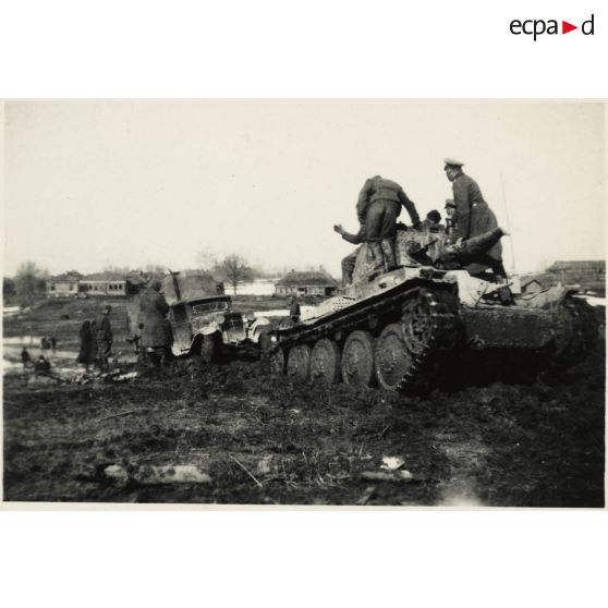 [Sur les routes détrempées du front de l'Est, un blindé léger Panzer 38 (t) tracte un camion SIS-5 d'origine soviétique].