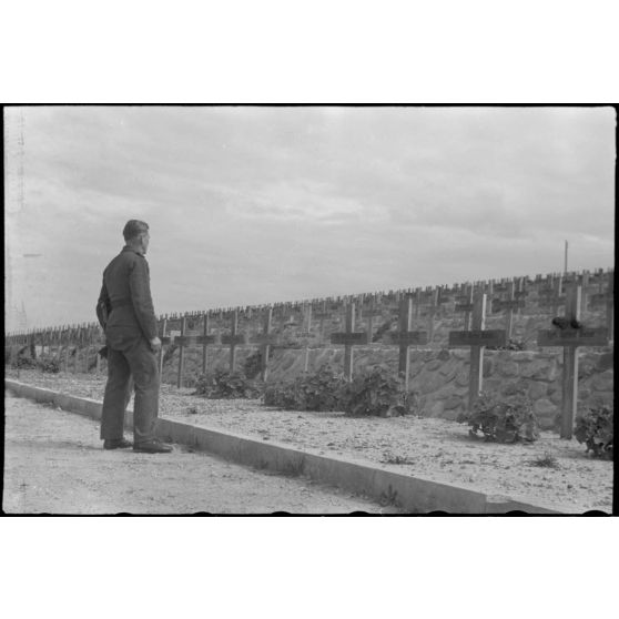 Au cimetière de Maleme (Crète), un caporal de la Luftwaffe se recueille devant des tombes de parachutistes allemandes tombés lors de l'opération Merkur.