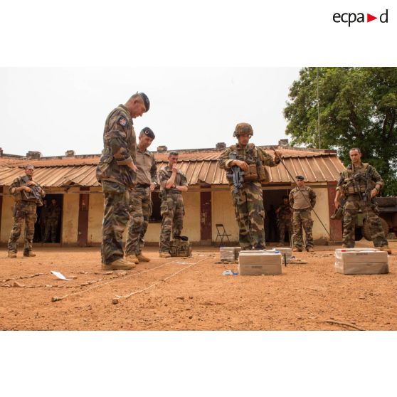 Au moyen d'une caisse à sable, un lieutenant de la compagnie rouge du GTIA (groupement tactique interarmes) Turco expose la situation des troupes françaises et celles de la MINUSCA (mission multidimensionnelle intégrée des Nations Unies pour la stabilisation en Centrafrique) dans la ville de Bambari, dans le cadre de la visite du général de brigade Eric Bellot des Minières, commandant la force Sangaris.
