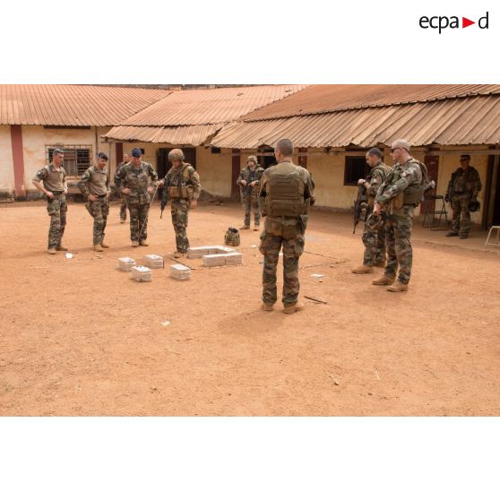 Au moyen d'une caisse à sable, un lieutenant de la compagnie rouge du GTIA (groupement tactique interarmes) Turco expose la situation des troupes françaises et celles de la MINUSCA (mission multidimensionnelle intégrée des Nations Unies pour la stabilisation en Centrafrique) dans la ville de Bambari, dans le cadre de la visite du général de brigade Eric Bellot des Minières, commandant la force Sangaris.