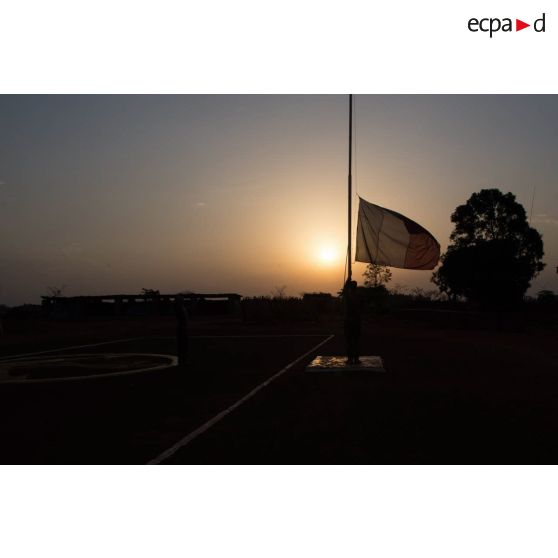 Tirailleur du GTIA (groupement tactique interarmes) Turco abaissant le drapeau lors de la cérémonie aux couleurs sur la place d'armes de la POD (plateforme opérationnelle défense) de Bambari, au soir du 13 mars 2015.