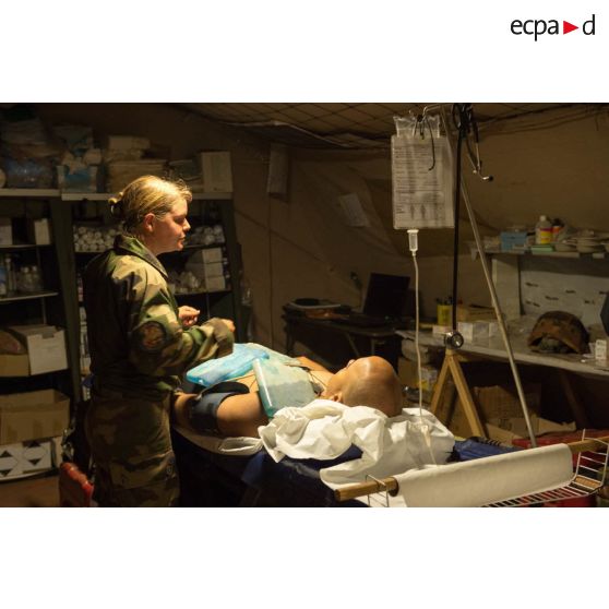 Une infirmière du rôle 1 ou poste médical avancé de la POD (plateforme opérationnelle de défense) de Bambari, apporte des soins à un soldat d'une section de la compagnie Verte du GTIA (groupement tactique interarmes) Turco par le personnel médical blessé lors d'une mission de protection de la gendarmerie et de la cour d'appel.