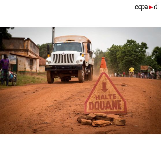 Panneau des douanes à Bambari, installé dans le cadre de la réouverture des bureaux douaniers et de l'installation dans la ville de l'ORCCPA (office de réglementation, de commercialisation et de conditionnement des produits agricoles). Un camion cargo  International Workstar y est stationné.
