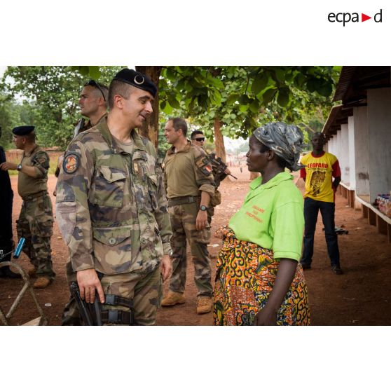 Le colonel Marc Espitalier, chef de corps du 1er RT et commandant le GTIA (groupement tactique interarmes) Turco converse avec une habitante au marché de Bambari, dans le cadre de la réouverture des bureaux douaniers de la ville et l'installation de l'ORCCPA (office de réglementation, de commercialisation et de conditionnement des produits agricoles).
