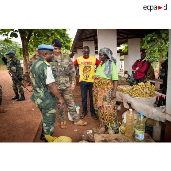 Le colonel Marc Espitalier, chef de corps du 1er RT et commandant le GTIA (groupement tactique interarmes) Turco converse avec une habitante au marché de Bambari en présence d'un lieutenant-colonel congolais des casques bleus de la MINUSCA (mission multidimensionnelle intégrée des Nations Unies pour la stabilisation en Centrafrique) , dans le cadre de la réouverture des bureaux douaniers de la ville et l'installation de l'ORCCPA (office de réglementation, de commercialisation et de conditionnement des produits agricoles).