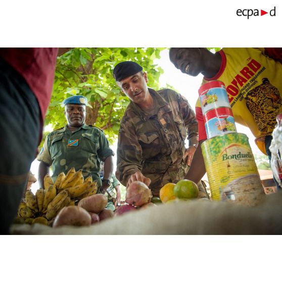 Le colonel Marc Espitalier, chef de corps du 1er RT et commandant le GTIA (groupement tactique interarmes) Turco, accompagné d'un lieutenant-colonel congolais des casques bleus de la MINUSCA (mission multidimensionnelle intégrée des Nations Unis pour la stabilisation en Centrafrique), achète des fruits au marché de Bambari, dans le cadre de la réouverture des bureaux douaniers de la ville et l'installation de l'ORCCPA (office de réglementation, de commercialisation et de conditionnement des produits agricoles).