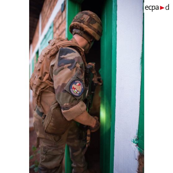 Un soldat d'une section du 3e RG du GTIA (groupement tactique interarmes) Turco progresse dans les locaux du marché central de Bambari, au cours d'une action quotidienne VNP (vérification de non pollution).