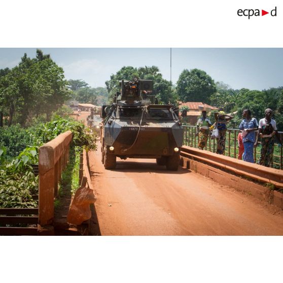 Un VAB TOP (tourelle télé-opérée) transportant les soldats de la 3e section de la compagnie Rouge du GTIA (groupement tactique interarmes) Turco, franchit un pont sous les yeux de quelques habitants lors d'une patrouille quotidienne dans les rues de Bambari.
