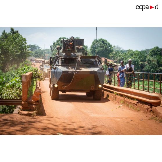 Un VAB TOP (tourelle télé-opérée) transportant les soldats de la 3e section de la compagnie Rouge du GTIA (groupement tactique interarmes) Turco, franchit un pont sous les yeux de quelques habitants lors d'une patrouille quotidienne dans les rues de Bambari.