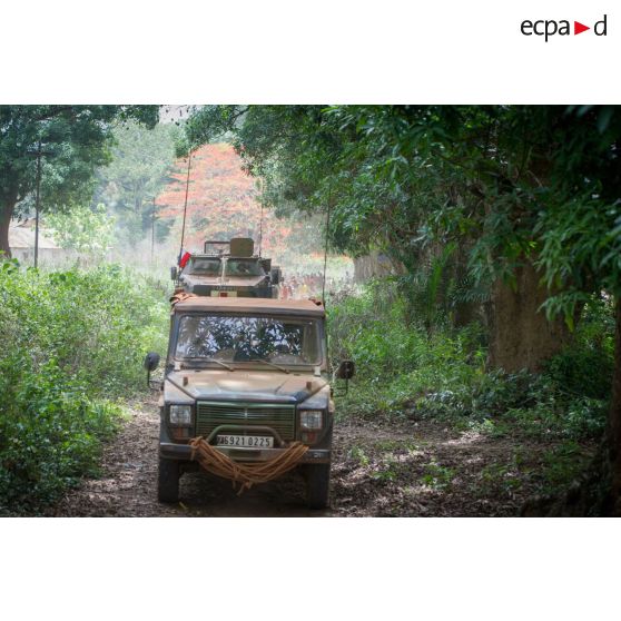 Une Peugeot P4 et un VAB sanitaire transportant le personnel du rôle 1 ou antenne médicale avancée du GTIA (groupement tactique interarmes) Turco, évoluent sur une route de campagne lors d'une reconnaissance du dispensaire du CRPR (centre régional polyvalent de recherche) de Bambari dans le cadre d'une AMP (aide médicale à la population).
