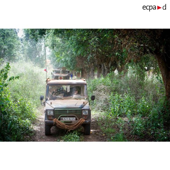 Une Peugeot P4 et un VAB sanitaire transportant le personnel du rôle 1 ou antenne médicale avancée du GTIA (groupement tactique interarmes) Turco, évoluent sur une route de campagne lors d'une reconnaissance du dispensaire du CRPR (centre régional polyvalent de recherche) de Bambari dans le cadre d'une AMP (aide médicale à la population).