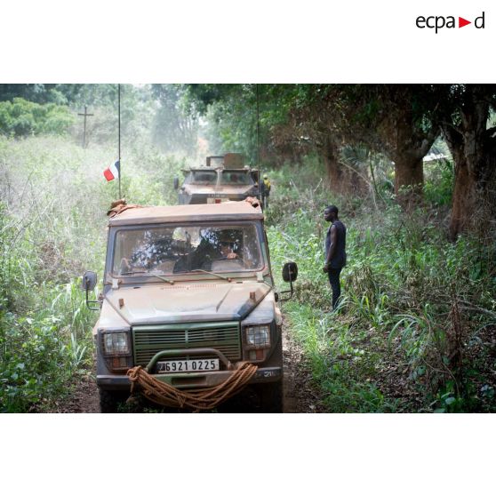 Une Peugeot P4 et un VAB sanitaire transportant le personnel du rôle 1 ou antenne médicale avancée du GTIA (groupement tactique interarmes) Turco, évoluent sur une route de campagne lors d'une reconnaissance du dispensaire du CRPR (centre régional polyvalent de recherche) de Bambari dans le cadre d'une AMP (aide médicale à la population).